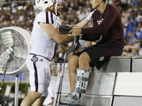 Texas A&M linebacker Cullen Gillaspia, left, checks on Texas A&M quarterback Nick Starkel, right, as he sits on the bench with an injury against UCLA during the second half of an NCAA college football game, Sunday, Sept. 3, 2017, in Pasadena, Calif. (AP Photo/Danny Moloshok)