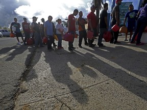 People wait in line for gas, in the aftermath of Hurricane Maria, in Aibonito, Puerto Rico, Monday, Sept. 25, 2017. The U.S. ramped up its response Monday to the humanitarian crisis in Puerto Rico while the Trump administration sought to blunt criticism that its response to Hurricane Maria has fallen short of it efforts in Texas and Florida after the recent hurricanes there. (AP Photo/Gerald Herbert)