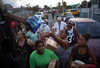 Puerto Ricans receive food and water being given out by volunteers and municipal police as they deal with the aftermath of Hurricane Maria on Sept. 28, 2017 in Toa Baja.