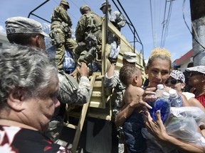 National Guard Soldiers arrive at Barrio Obrero in Santurce to distribute water and food among those affected by the passage of Hurricane Maria, in San Juan, Puerto Rico.