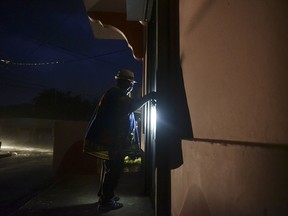 A woman closes her property in the coastal area hours before the imminent impact of Maria, a Category 5 hurricane that threatens to hit the eastern region of the island with sustained winds of 165 miles per hour, in Naguabo, Puerto Rico, Tuesday, September 19, 2017.