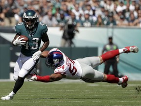 Philadelphia Eagles' Darren Sproles, left, tries to slip past New York Giants' Olivier Vernon during the first half of an NFL football game, Sunday, Sept. 24, 2017, in Philadelphia. (AP Photo/Michael Perez)