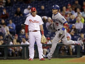 Los Angeles Dodgers' Yasmani Grandal, right, rounds the bases past Philadelphia Phillies first baseman Rhys Hoskins after hitting a home run during the third inning of a baseball game, Tuesday, Sept. 19, 2017, in Philadelphia. (AP Photo/Matt Slocum)