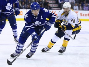 In this Nov. 21, 2013 file photo, Toronto Maple Leafs forward Joffrey Lupul (left) controls the puck against the Nashville Predators.