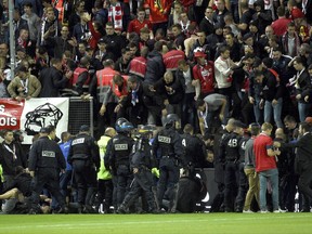 Stadium stewards and police officers gather to help wounded Lille' supporters following the fall of a barrier during a French League One soccer match between Amiens and Lille in Amiens, northern France, Saturday, Sept. 30, 2017. Three Lille supporters have been seriously injured and taken to hospital after a barrier collapsed during the side's football match at Amiens. Lille says 17 other fans were also injured. (AP Photo)