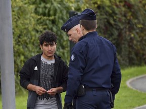 French police officers evacuate migrants from a makeshift camp in Grand-Synthe, near Dunkirk, northern France, Tuesday, Sept. 19, 2017. The prefecture of the Nord region said that 240 people had been evacuated from the camp so far, and the operation was continuing. (AP Photo)