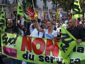 Demonstrators take part in a march against President Emmanuel Macron's new pro-business labor policies in Paris, France, Thursday, Sept. 21, 2017. Sticker reads : I am an idler. President Emmanuel Macron's presidency is facing its second big public test, as unions hold nationwide protests against changes to labor laws that they fear corrode hard-fought job security. (AP Photo/Francois Mori)