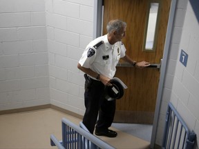 In this Monday, July 31, 2017 photo Barrington, R.I., Police Chief John LaCross steps through a stairwell at the police station, in Barrington. LaCross, who lost his brother to suicide in 1979, and has met with mediums, believes there is a growing trend of people turning to psychics after losing a loved one. (AP Photo/Steven Senne)