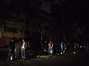 People who evacuated from bars during an earthquake stand in the street in La Roma neighborhood of Mexico City, sections of which lost power, just before midnight on Thursday, Sept. 7, 2017. A massive earthquake hit off the coast of southern Mexico late Thursday night, causing buildings to sway violently and people to flee into o the streets in panic as far away as the capital city. (AP Photo/Rebecca Blackwell)