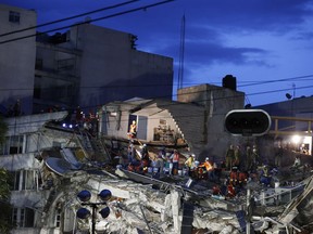 Rescuers race to save people believed to be still alive inside a collapsed office building in the Roma Norte neighborhood of Mexico City, as night falls Friday, Sept. 22, 2017, three days after a 7.1 magnitude earthquake. Hope mixed with fear Friday in Mexico City, where families huddled under tarps and donated blankets, awaiting word of their loved ones trapped in rubble. (AP Photo/Rebecca Blackwell)