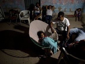 Neighbors camp out in an alley at night, afraid to spend time inside their heavily damaged homes, in a zone affected by Thursday's magnitude 8.1 earthquake, in Juchitan, Oaxaca state, Mexico, Monday, Sept. 11, 2017. Life for many has moved outdoors in the quake-shocked city of Juchitan, where a third of the homes are reported uninhabitable and repeated aftershocks have scared people away from many structures still standing. (AP Photo/Rebecca Blackwell)