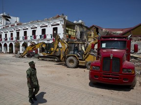 Excavation work continues on City Hall which had partially collapsed in Thursday's magnitude 8.1 earthquake, in Juchitan, Oaxaca state, Mexico, Saturday, Sept. 9, 2017. Workers Saturday found the body of a municipal police officer in the rubble who had been missing. (AP Photo/Rebecca Blackwell)