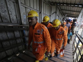 Members of the National Disaster Response Force team arrive at the pedestrian bridge where a stampede took place at the Elphinstone station, in Mumbai, India, Friday, Sept. 29, 2017. The stampede broke out on a crowded pedestrian bridge connecting two railway stations in Mumbai during the Friday morning rush, killing a number of people police said. (AP Photo/Rafiq Maqbool)