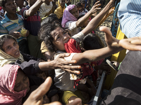 Desperate Rohingya refugees reach for aid handouts of clothing and food on Sept. 15, 2017 in Tankhali, Bangladesh.