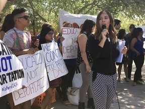 Korina Iribe, right, speaks to immigrant rights groups, advocating for DACA, the program that allows youths who were brought to the country illegally as children to legally work and be shielded from deportation, during a rally in Phoenix, Ariz., Monday, Aug. 28, 2017. President Donald Trump is deciding whether to keep the program as Republican officials from 10 states have threatened to sue to stop the program, giving Trump a Sept. 5 deadline to act. (AP Photo/Astrid Galvan)