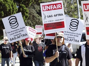 In this photo taken Nov. 3, 2016, video game voice actors picket outside Warner Bros. Studios in Burbank, Calif. The voice actors have agreed to end a nearly yearlong strike against several major gaming publishers. Their union, SAG-AFTRA, and a representative for the publishers said Monday, Sept. 25, 2017, that they reached a tentative agreement to end the strike on Saturday, Sept. 23. (AP Photo/Anthony McCartney)