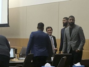 From left, Gerald Bowman, defense attorney Jim Belanger, Markieff Morris and Markieff Morristalk appear in the courtroom following opening statements made by attorneys Monday, Sept. 18, 2017, in Phoenix. The NBA players went on trial Monday on felony assault charges stemming from a 2015 beating that prosecutors labeled as an "orchestrated attack" and defense lawyers dismissed as a ploy to get money out of the athletes. (AP Photo/Clarice Silber)