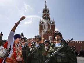 In this file photo taken on Wednesday, Aug. 2, 2017 Russian Orthodox priest blesses paratroopers during celebrations of Paratroopers Day in the Red Square in Moscow, Russia