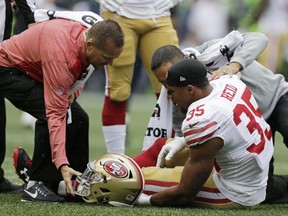 San Francisco 49ers strong safety Eric Reid (35) is tended to on the field after an injury in the first half of an NFL football game against the Seattle Seahawks, Sunday, Sept. 17, 2017, in Seattle. (AP Photo/John Froschauer)