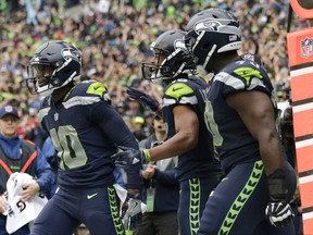 Seattle Seahawks wide receiver Paul Richardson, left, is greeted by teammates Tyler Lockett, center, and Rees Odhiambo, right, after Richardson caught a pass for a touchdown against the San Francisco 49ers in the second half of an NFL football game, Sunday, Sept. 17, 2017, in Seattle. (AP Photo/John Froschauer)
