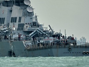 The guided-missile destroyer USS John S. McCain, with a hole on its port side after a collision with an oil tanker.