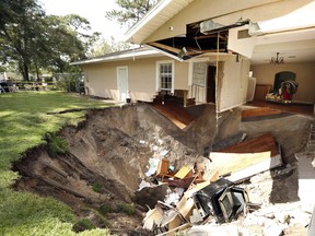 A home at 222 West Kelly Park Road in Apopka, Fla., is being swallowed by a sinkhole on Tuesday, Sept. 19, 2017. Orange County Fire Rescue spokeswoman Kat Kennedy says crews responded Tuesday morning, shortly after the Apopka house began sinking. She says the sinkhole measured about 20 feet across and 15 feet deep. No injuries were reported to the home's residents. Kennedy says they're staying with relatives. (Stephen M. Dowell /Orlando Sentinel via AP) ORG XMIT: FLORL102