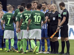 Referee Bibiana Steinhaus, 2nd right, shakes hand with players prior to the German Bundesliga soccer match between Hertha BSC Berlin and SV Werder Bremen in Berlin, Germany, Sunday, Sept. 10, 2017. (AP Photo/Michael Sohn)