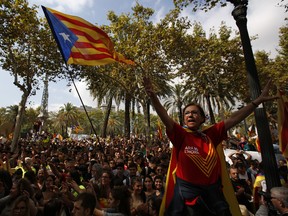A woman gestures as others wave the estelada' or Catalonia independence flags during a protest in Barcelona, Spain Thursday, Sept. 21, 2017