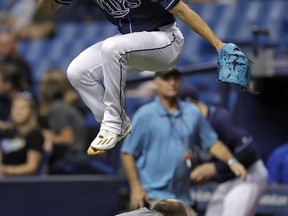 Tampa Bay Rays starting pitcher Chris Archer leaps over Tampa Bay Times photographer Will Vragovic as he takes the field before a baseball game against the Baltimore Orioles, Saturday, Sept. 30, 2017, in St. Petersburg, Fla. (AP Photo/Chris O'Meara)