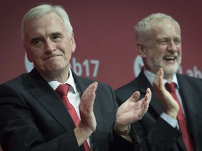 Britain's Shadow chancellor John McDonnell, left, is congratulated by Labour Party leader Jeremy Corbyn  after his speech at the Labour Party conference at the Brighton Centre, Brighton, England, Monday Sept. 25, 2017. (Stefan Rousseau/PA via AP)