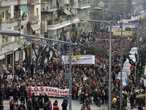 FILE - In this March 9, 2013 file photo, demonstrators shout slogans during a protest in Thessaloniki, Greece as more than 10,000 people took to the streets to protest against a planned gold mine operation by Canadian company Eldorado Gold Corp.  Eldorado Gold plans to suspend investment at its mines in Greece following what it says are government delays in the issuing of permits and licenses. Eldorado said in an announcement Monday, Sept. 11, 2017 it would continue maintenance and environmental safeguards but would make no further investment in three mines in the Halkidiki area of northern Greece and two projects in the northeastern province of Thrace. The banner in the middle shows the pictures of three former socialist ministers and reads "they signed the disastrous deal." (AP Photo/Nikolas Giakoumidis, File)