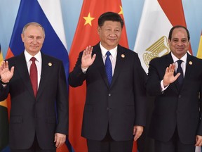 Russian President Vladimir Putin, left, Chinese President Xi Jinping, center, Egypt's President Abdel-Fattah el-Sissi wave the hands during the group photo session, ahead of Dialogue of Emerging Market and Developing Countries, on the sidelines of the BRICS summit in Xiamen, Fujian province in China, Tuesday, Sept. 5, 2017.(Kenzaburo Fukuhara/Pool Photo via AP)