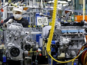In this Aug. 2, 2017, photo, a Nissan Motor Co. factory worker checks an engine on an assembly line at its plant in Yokohama, near Tokyo. Aiming to get an edge on its rivals in an intensely competitive industry, Japanese automaker Nissan says it's attempting to foster a corporate culture that will produce manufacturing innovations in leaps and bounds instead of steady incremental improvement. Its discussion of that effort is partly a swipe at bigger competitor Toyota Motor Corp. which for decades has favored the concept of "kaizen" or fine tuning and bit-by-bit progress in auto manufacturing. (AP Photo/Shizuo Kambayashi)