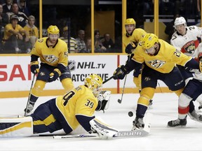 Nashville Predators goalie Anders Lindback (39), of Sweden, reaches to block a shot as right wing Miikka Salomaki (20), of Finland, keeps Florida Panthers right wing Evgenii Dadonov (63) away during the third period of the second game in an NHL hockey preseason doubleheader Tuesday, Sept. 19, 2017, in Nashville, Tenn. The Predators won 3-2 in overtime. (AP Photo/Mark Humphrey)