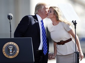 President Donald Trump kisses his daughter Ivanka Trump before speaking about tax reform at the Andeavor Mandan Refinery, Wednesday, Sept. 6, 2017, in Mandan, N.D.