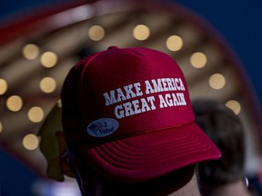 An attendee wearing a hat reading "Make America Great Again" waits for the arrival of Donald Trump, 2016 Republican presidential nominee, during a campaign event in Cedar Rapids, Iowa, U.S., on Friday, Oct. 28, 2016.
