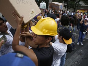 Volunteers load emergency supplies to take to another earthquake stricken area, in the Linda Vista neighborhood of Mexico City, Wednesday, Sept. 20, 2017. People by the millions rushed from homes and offices across central Mexico, after a 7.1 earthquake, sometimes watching as buildings they had just fled fell behind them with an eruption of dust and debris. (AP Photo/Rebecca Blackwell)