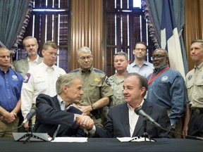 Gov. Greg Abbott, left, announces that Texas A&M University System Chancellor John Sharp, right, will head the Rebuild Texas initiative following Hurricane Harvey, Thursday, Sept. 7, 2017, at the Capitol in Austin, Texas. (Jay Janner/Austin American-Statesman via AP)