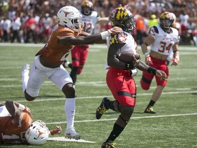 Maryland quarterback Tyrrell Pigrome, front right, eludes Texas' Kris Boyd for a touchdown during second-quarter NCAA college football game action in Austin, Texas, Saturday, Sept. 2, 2017. (Ralph Barrera/Austin American-Statesman via AP)