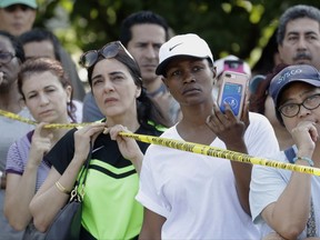 Residents listen to officials at a roadblock into their Canyon Gate neighborhood which was flooded when the Barker Reservoir reached capacity in the aftermath of Harvey on Saturday, Sept. 2, 2017, in Katy, Texas. Residents gathered at the checkpoint to vent their frustrations about not being able to get back into their homes which will remain flooded for several more days while the reservoir drains. (AP Photo/Charlie Riedel)