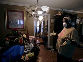 Lois Rose looks over belongings while salvaging items from her flood-damaged house Thursday, Aug. 31, 2017, in Houston. The city continues to recover from record flooding caused by Hurricane Harvey. (AP Photo/Charlie Riedel)