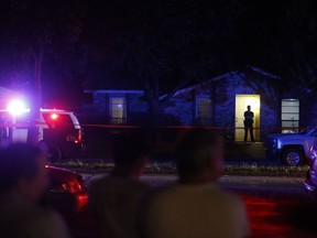 Onlookers watch police work the scene of a shooting at a home in Plano, north of Dallas, Texas, Sunday night, Sept. 10, 2017. Authorities in North Texas say several people are dead, including the suspect, after a shooting at the Plano home. (Vernon Bryant/The Dallas Morning News via AP)