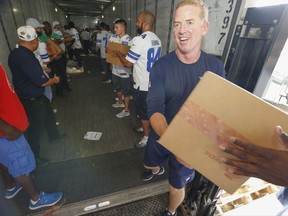 Dallas Cowboys head coach Jason Garrett, team members and The Salvation Army personnel unload 300,000 pieces of donated apparel off a tractor trailer at The Salvation Army Adult Rehabilitation Center Thursday, Aug. 31, 2017. Clothing items include men's, women's and children's tee shirts, fleece, outerwear and rompers worth approximately $500,000. (Ron Baselice/The Dallas Morning News via AP)