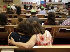 Debbie Uzick, right, puts her arm around Natalie Hausman-Weiss during a Bar Mitzvah on Saturday, Sept. 2, 2017, in Houston. Both of their homes were flooded in the aftermath of Harvey. (AP Photo/David J. Phillip)