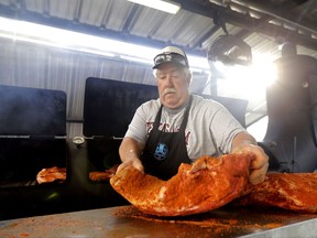 Rock Moye, from Austin, Texas, prepares brisket to serve to volunteers and flood victims in the aftermath of Hurricane Harvey on Sunday, Sept. 3, 2017, in Cypress, Texas. (AP Photo/David J. Phillip)