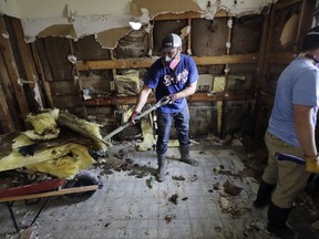 Volunteers Brock Warnick, right, and Colten Roberts remove drywall and insulation from the home of Julia Lluvia which was damaged by floodwaters in the aftermath of Hurricane Harvey Monday, Sept. 4, 2017, in Houston. (AP Photo/David J. Phillip)