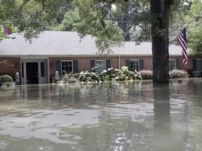 A United States flag hangs outside a flooded home in the aftermath of Hurricane Harvey, Monday, Sept. 4, 2017, near the Addicks and Barker Reservoirs in Houston. (AP Photo/David J. Phillip)