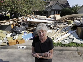 In this Monday, Sept. 11, 2017, photo, Arlene Estle stands outside her home which was damaged by floodwaters from Hurricane Harvey, in Houston. Victims of Harvey, desperate to rebuild their homes and lives, are facing the harsh reality that it may take months for an overwhelmed construction industry to address their needs. (AP Photo/David J. Phillip)