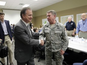 In this Sept. 14, 2017 photo, Commissioner John Sharp shakes hands with Maj. Gen. John F. Nichols, right, as he arrives for a briefing on Hurricane Harvey recovery efforts at the new FEMA Joint Field Office, in Austin, Texas. Sharp, the recovery czar over Texas' rebuild after Harvey, says his new job is "future-proofing" for the next disaster. (AP Photo/Eric Gay)