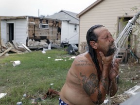 In this Sept. 2, 2017, photo, Bob Campbell baths outdoors using a makeshift shower he attached to a garden hose, in Port Aransas, Texas. Rockport and Port Aransas bore the brunt of one of the strongest hurricanes to hit the United States. (AP Photo/Eric Gay)